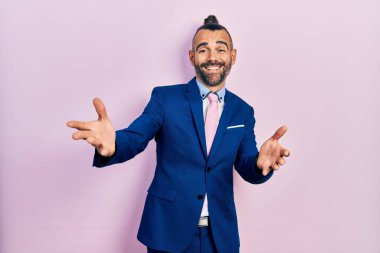 Genç İspanyol takım elbiseli ve kravatlı neşeli gülümseyerek yardım eli uzatıyor ve kabul ediyor.. 