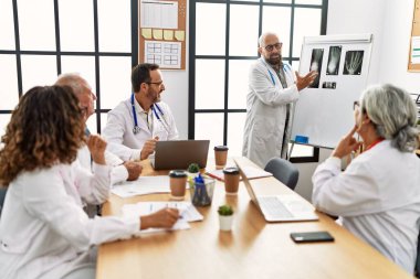 Bir grup orta yaşlı doktor klinikteki bir tıbbi toplantıda tartışıyorlar..
