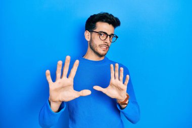 Gündelik kıyafetler ve gözlük takan genç İspanyol adam tiksindirici tepki verdiği için tiksinmiş ve korkmuş bir ifade takınıyordu. Eller havada. 