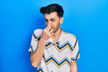 Gündelik kıyafetler giyen genç İspanyol adam pis ve iğrenç bir koku alıyor, dayanılmaz bir koku, nefesini burnunda tutuyor. Kötü kokuyor. 