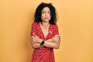 Yaz elbisesi giyen genç Latin kız kış soğuğu için titriyor ve donuyor. Yüzünde üzgün ve şok ifadesi var. 