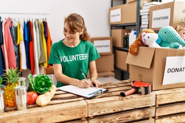 Yardım merkezinde çalışmaktan mutlu gülümseyen beyaz bir kadın..