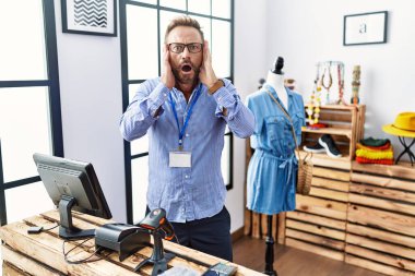 Orta yaşlı bir adam perakende mağazasında yönetici olarak çalışıyor. Korkmuş ve şok olmuş, şaşırmış ve şaşırmış bir yüz ifadesi var. 