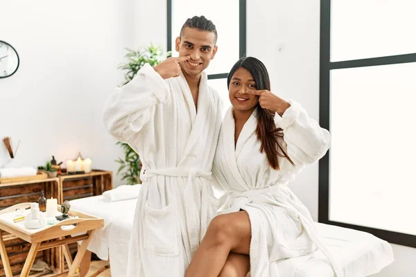 Young Latin Couple Wearing Towel Standing Beauty Center Pointing Hand — Foto Stock