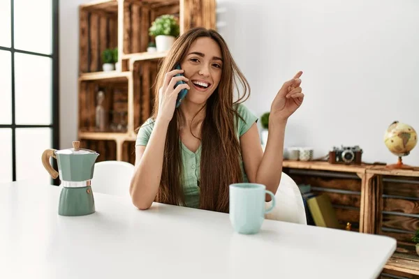 Young Hispanic Woman Talking Smartphone Sitting Table Home Smiling Happy — Stockfoto