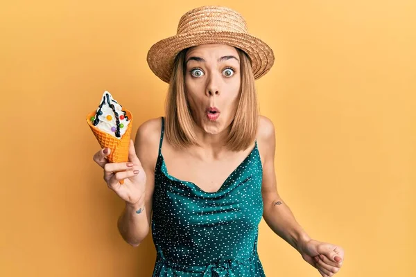 若いですCaucasianブロンド女性食べるアイスクリーム怖がってと驚きのために口を開けて 不信顔 — ストック写真