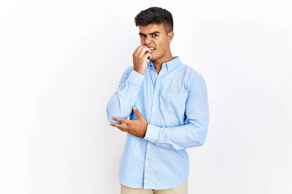穿着商务衬衫站在孤立的背景下的年轻人显得紧张而紧张 双手放在咬指甲的嘴上 焦虑问题 — 图库照片
