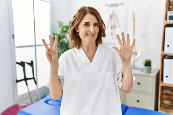 Mulher Fisioterapeuta Meia Idade Trabalhando Clínica Recuperação Dor Mostrando Apontando — Fotografia de Stock