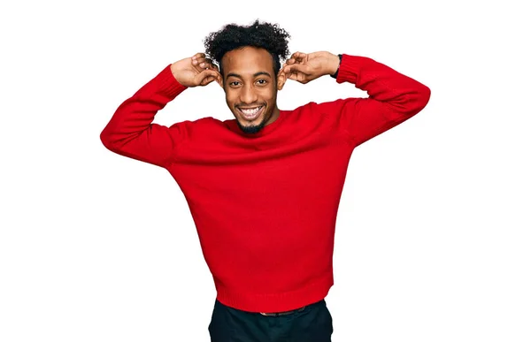 カジュアルな冬のセーターを着てひげを生やして若いアフリカ系アメリカ人の男性は 指で耳を引く笑みを浮かべて 面白いジェスチャー オーディション問題 — ストック写真