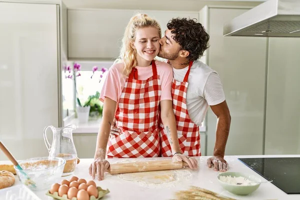 Młoda Para Uśmiechnięta Szczęśliwa Ugniatając Ciasto Rękami Kuchni — Zdjęcie stockowe