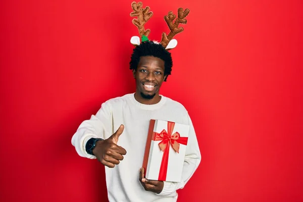 Mladý Africký Američan Jelením Vánočním Kloboukem Který Drží Dárek Dělá — Stock fotografie