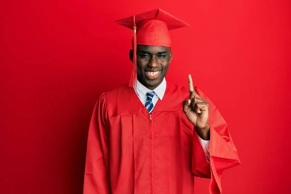 Mladý Africký Američan Muž Sobě Maturitní Čepici Slavnostní Župan Ukazuje — Stock fotografie