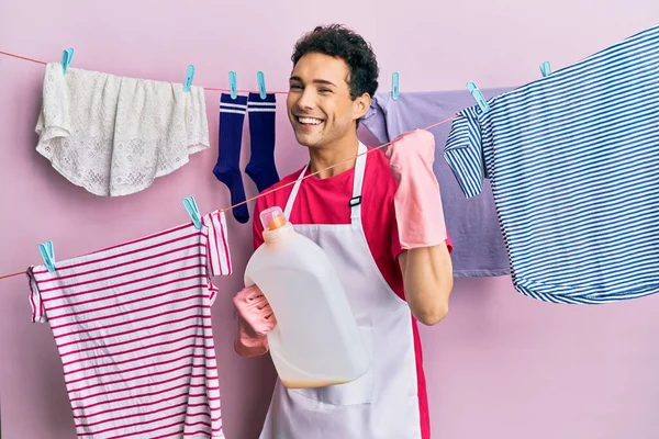 Hombre Hispano Guapo Lavando Ropa Sosteniendo Botella Detergente Gritando Orgulloso — Foto de Stock