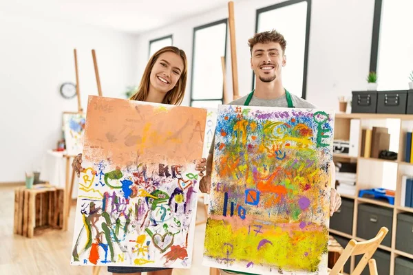 Joven Pareja Artistas Hispanos Sonriendo Feliz Mostrando Dibujo Lona Estudio —  Fotos de Stock