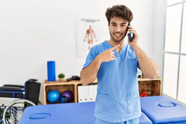 Spanischer Physiotherapeut Arbeitet Schmerzklinik Und Telefoniert Glücklich Lächelnd Mit Hand — Stockfoto