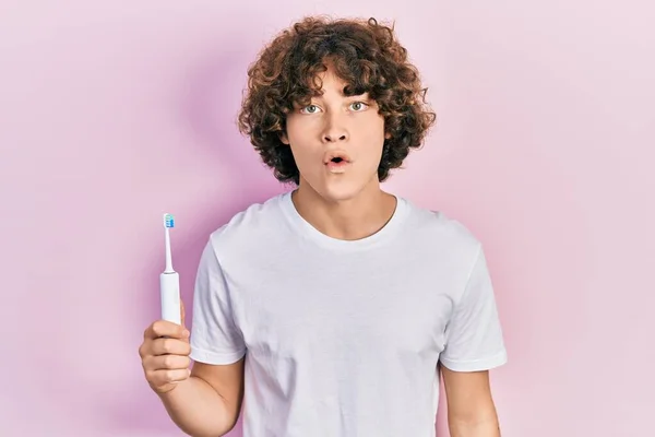 Handsome Young Man Holding Electric Toothbrush Scared Amazed Open Mouth — Stock Photo, Image