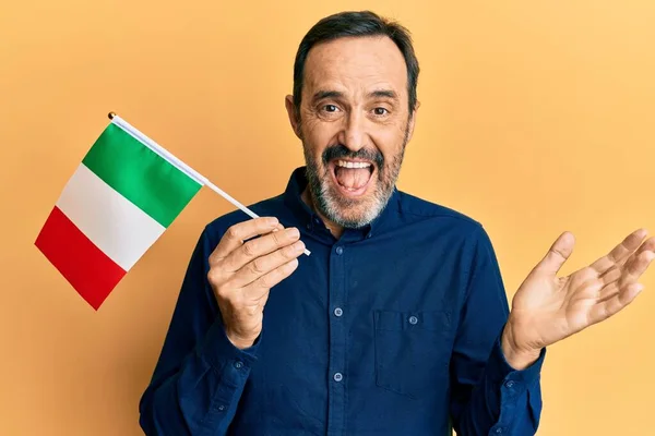 Středověký Hispánec Drží Italskou Vlajku Oslavující Úspěch Šťastným Úsměvem Vítězným — Stock fotografie