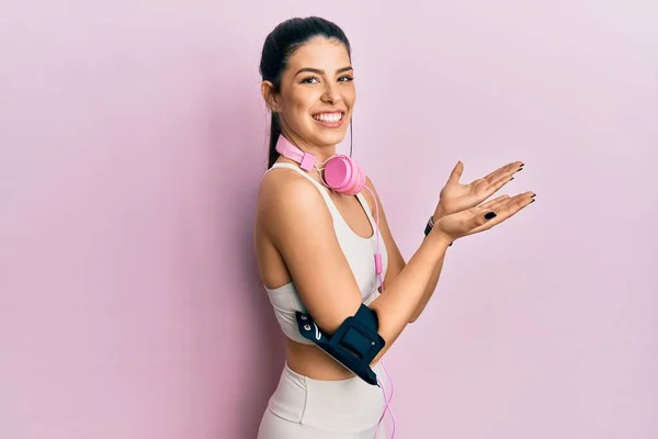 Ung Latinamerikansk Kvinna Bär Gym Kläder Och Använda Hörlurar Pekar — Stockfoto