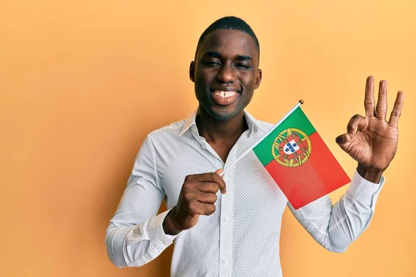 Joven Hombre Afroamericano Sosteniendo Bandera Portugal Haciendo Signo Con Los —  Fotos de Stock