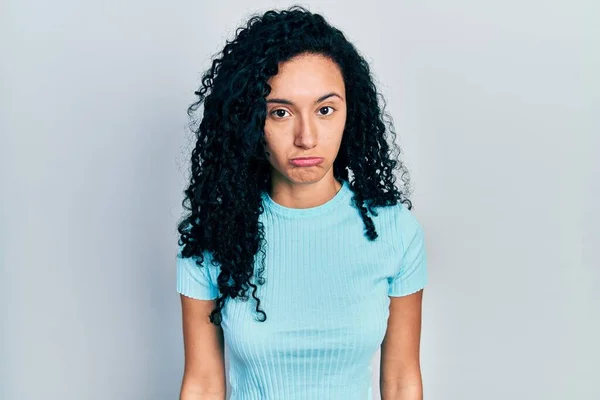 巻き毛の若いヒスパニック系の女性は カジュアルな青のTシャツを着て落ち込んで苦痛を心配し 怒っていると恐れて泣いています 悲しい表情 — ストック写真