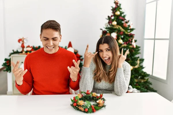 Jovem Casal Hispânico Sentado Mesa Natal Gritando Com Expressão Louca — Fotografia de Stock