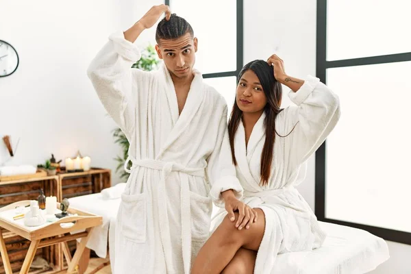 Young Latin Couple Wearing Towel Standing Beauty Center Confuse Wondering — Stockfoto