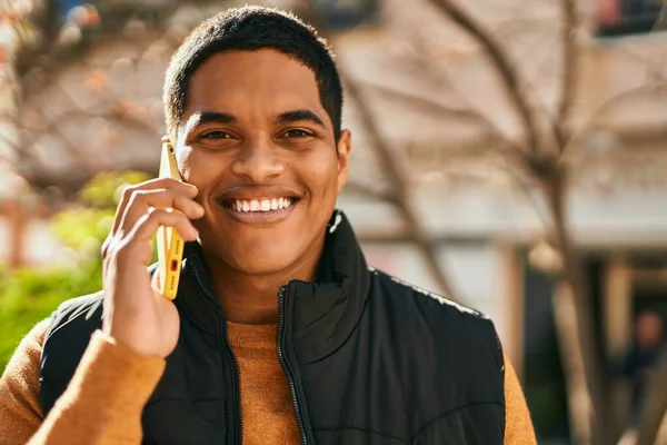 Young latin man smiling happy talking on the smartphone at the city