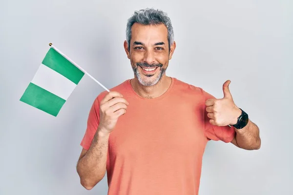 Snygg Medelålders Man Med Grått Hår Håller Nigeria Flagga Ler — Stockfoto