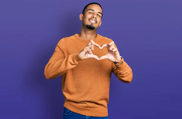年轻的非洲裔美国人穿着休闲装 带着爱心微笑 用手做着心形符号 浪漫的概念 — 图库照片