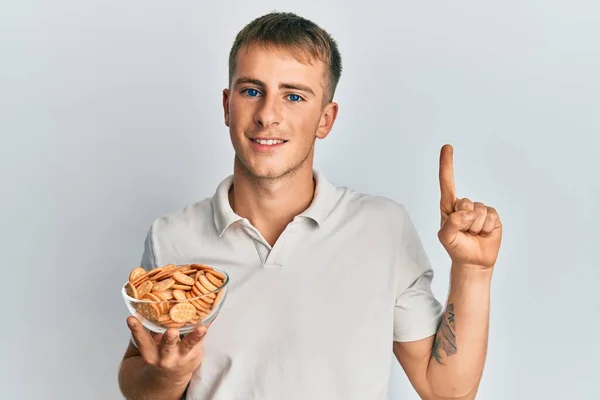 Jeune Homme Caucasien Tenant Bol Biscuits Salés Souriant Avec Une — Photo
