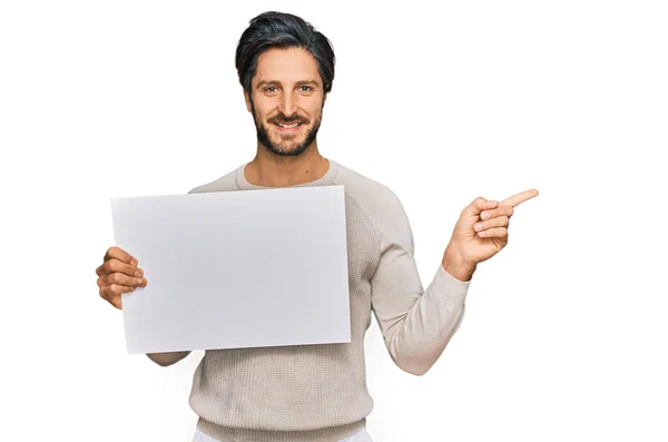 Young Hispanic Man Holding Blank Empty Banner Smiling Happy Pointing — Stock Photo, Image