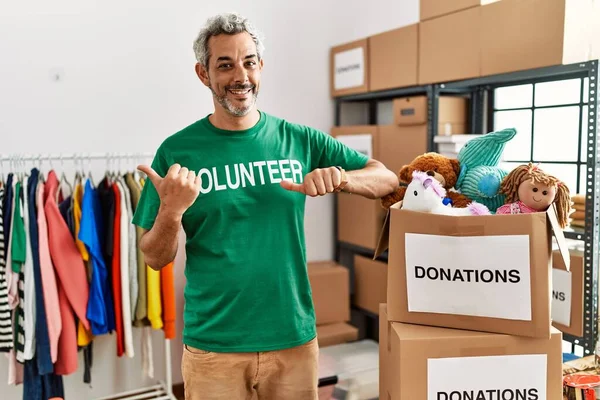 Homem Hispânico Meia Idade Vestindo Shirt Voluntária Doações Stand Apontando — Fotografia de Stock