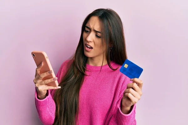 Junges Hispanisches Mädchen Mit Smartphone Und Kreditkarte Schockgesicht Sieht Skeptisch — Stockfoto