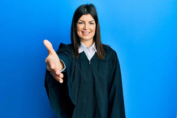 身穿法官制服的年轻惊慌失措的女人面带微笑友好地握手致意和欢迎 成功的商业 — 图库照片