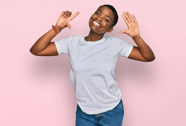 티셔츠를 자신감 행복하게 웃으면서 손가락으로 가리키는 아프리카계 — 스톡 사진