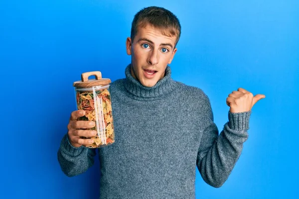 Jeune Homme Caucasien Tenant Pot Pâtes Crues Pointant Pouce Vers — Photo