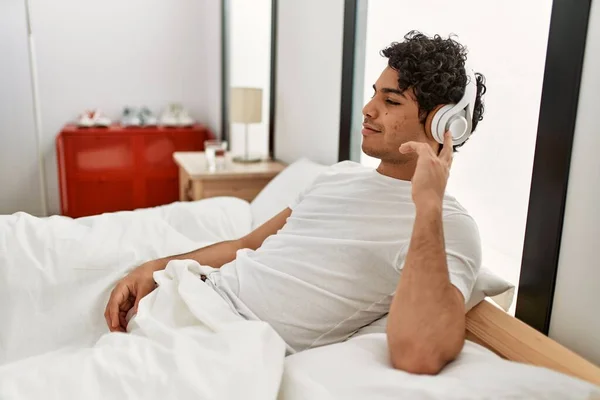 Молодий Іспаномовний Чоловік Слухає Музику Сидячи Ліжку Спальні — стокове фото