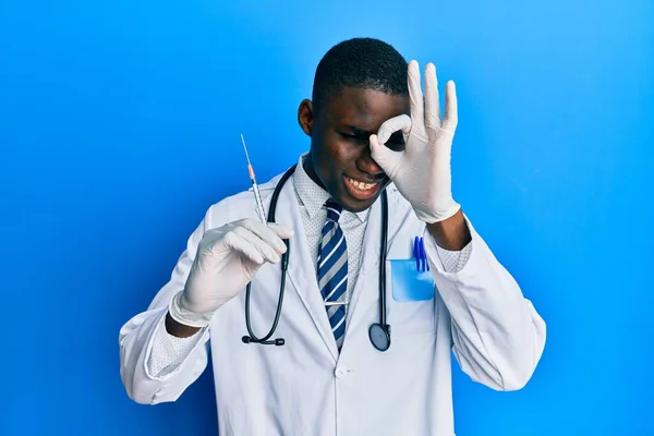 Joven Afroamericano Médico Hombre Sosteniendo Jeringa Sonriendo Feliz Haciendo Signo — Foto de Stock