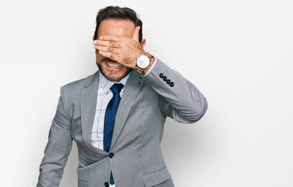 ビジネス用の服を着た中年男性が笑顔で手を顔に笑いながら驚きの目を覆います 視覚障害の概念 — ストック写真