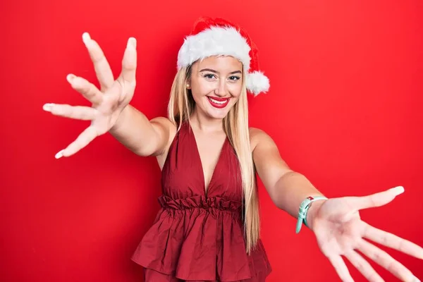 Genç Sarışın Kız Noel Şapkası Takmış Kameraya Bakıyor Sarılmak Için — Stok fotoğraf