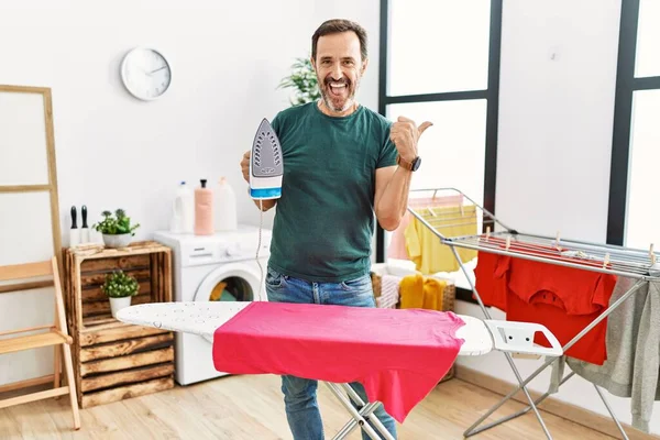 Hombre Mediana Edad Con Barba Planchando Ropa Casa Apuntando Pulgar —  Fotos de Stock