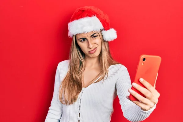 Όμορφη Ισπανόφωνη Γυναίκα Που Φοράει Χριστουγεννιάτικο Καπέλο Χρησιμοποιώντας Smartphone Ανίδεη — Φωτογραφία Αρχείου