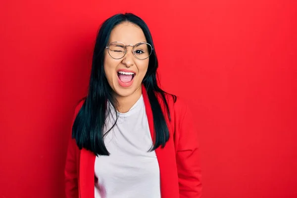 Beautiful hispanic woman with nose piercing wearing casual look and glasses winking looking at the camera with sexy expression, cheerful and happy face. — Stock Image Beautiful Hispanic Woman Nose Piercing Wearing Casual Look Glasses Winking Royalty Free Stock Photos