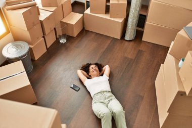 Orta yaşlı İspanyol kadın yeni evinde kendine güvenen gözlüklü gülümsüyor.