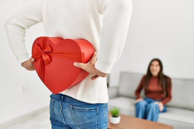 Genç İspanyol çift gülümsüyor. Sevgililer günü hediyesiyle mutlu bir sürpriz..