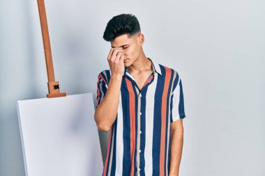 Genç İspanyol bir adam boş tuvale yakın duruyor. Burnu ve gözleri ovuşturmaktan yorulmuş, yorgunluk ve baş ağrısı çekiyor. Stres ve hüsran kavramı. 