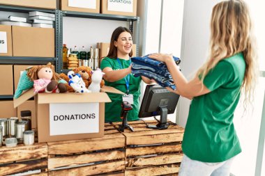 Genç gönüllü kız yardım merkezinde kadına yardım ediyor..