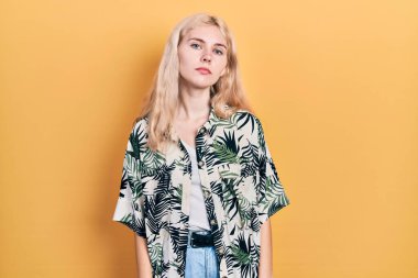 Sarışın, tropikal gömlek giyen, yüzü ciddi bir ifadeyle gevşemiş güzel beyaz bir kadın. Basit ve doğal bir şekilde kameraya bakıyorsun.. 