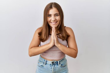 Genç esmer kadın izole edilmiş arka planda duruyor. Birlikte dua ediyor, af diliyor. Kendine güvenen gülümsüyor.. 