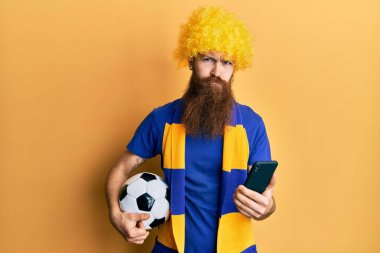 Kızıl saçlı, uzun sakallı futbol holiganları tezahürat yapan, akıllı telefonları kuşkucu ve gergin tutan, sorun yüzünden surat asan bir adam. negatif kişi. 